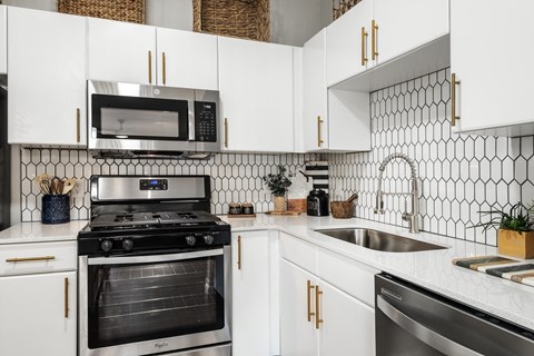 a kitchen with white cabinets and black appliances and a sink